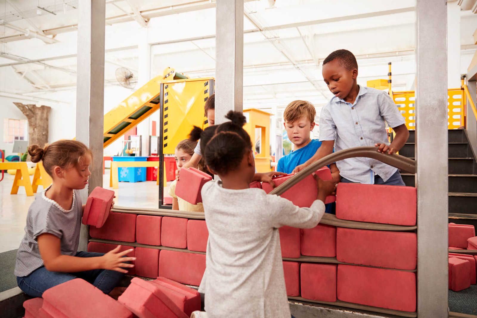 Niños construyendo con piezas en un taller creativo