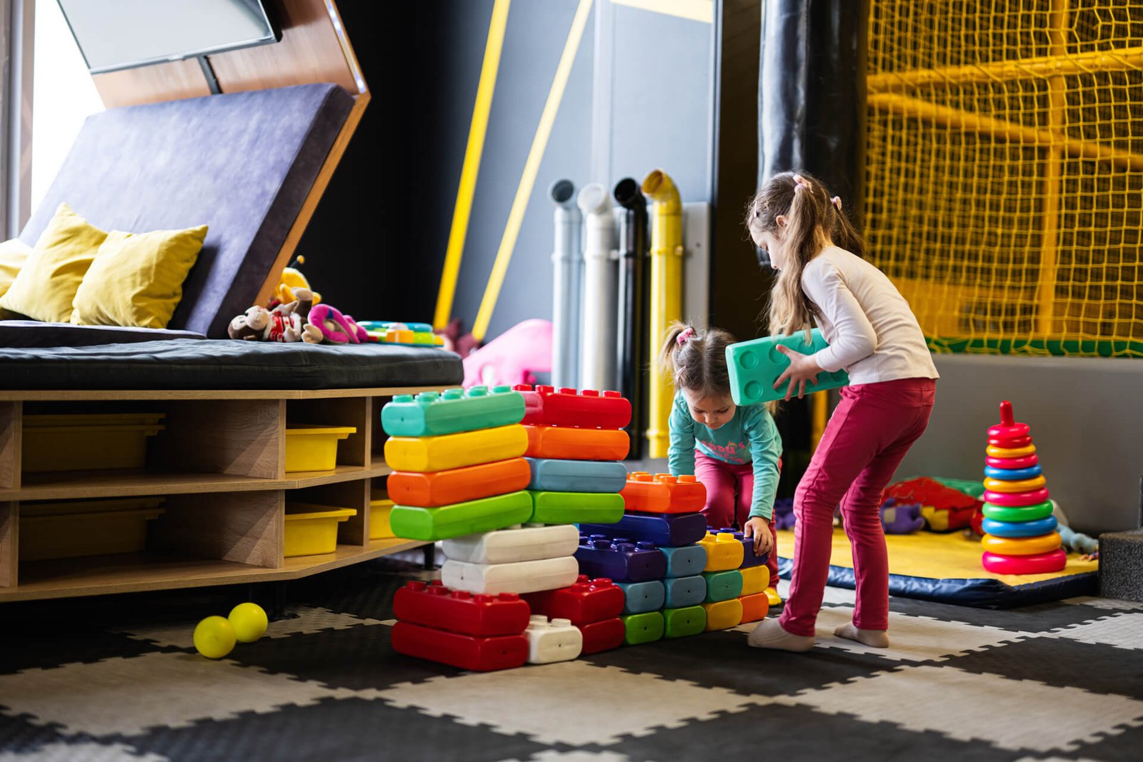 Dos hermanas jugando en el centro de juego infantil